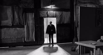 Movie still from “Ed Wood” (1994), directed by Tim Burton – A black and white photo of a man standing in a doorway; Wide shot, Low angle
