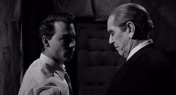 Movie still from “Ed Wood” (1994), directed by Tim Burton – A man standing next to another man in front of a couch; Close Up shot, Low angle