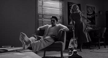 Movie still from “Ed Wood” (1994), directed by Tim Burton – A man and a woman in a room with a vacuum cleaner; Wide shot, Low angle