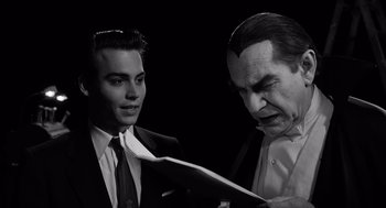 Movie still from “Ed Wood” (1994), directed by Tim Burton – A man in a suit and tie next to another man in a suit and tie; Medium shot, Over the shoulder angle