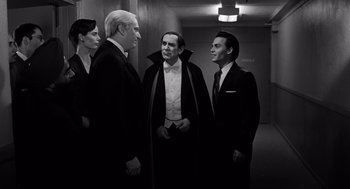 Movie still from “Ed Wood” (1994), directed by Tim Burton – A black and white photo of a group of people in tuxedos; Medium shot, Low angle