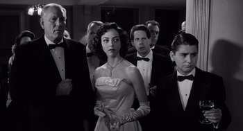 Movie still from “Ed Wood” (1994), directed by Tim Burton – A group of people standing around a woman in a dress; Medium shot, Low angle