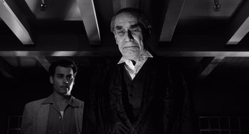 Movie still from “Ed Wood” (1994), directed by Tim Burton – A man standing next to another man in a room; Medium shot, Low angle