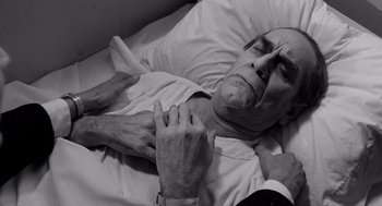 Movie still from “Ed Wood” (1994), directed by Tim Burton – An older man laying in bed with a hand on his chest; Close Up shot, High angle