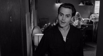 Movie still from “Ed Wood” (1994), directed by Tim Burton – A man in a black shirt is standing in a room; Medium shot, Over the shoulder angle
