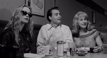 Movie still from “Ed Wood” (1994), directed by Tim Burton – A man and two women sitting at a table in a restaurant; Medium shot, Low angle