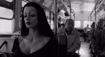 Movie still from “Ed Wood” (1994), directed by Tim Burton – A woman with long black hair sitting on a public bus; Medium shot, Over the shoulder angle