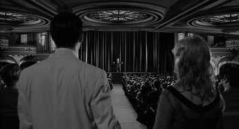 Movie still from “Ed Wood” (1994), directed by Tim Burton – A man standing in front of an audience in front of a curtain; Wide shot, Over the shoulder angle