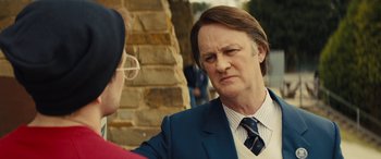 Movie still from “Eddie the Eagle” (2015), directed by Dexter Fletcher – A man in a blue suit and a man in a red shirt; Close Up shot, Over the shoulder angle