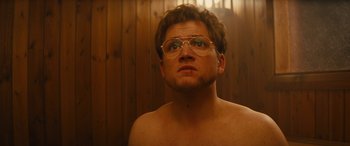 Movie still from “Eddie the Eagle” (2015), directed by Dexter Fletcher – A man with glasses is looking up at the sky; Close Up shot, Low angle