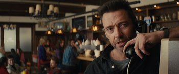 Movie still from “Eddie the Eagle” (2015), directed by Dexter Fletcher – A person with a cell phone; Close Up shot, Over the shoulder angle