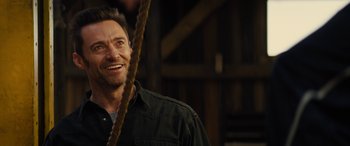 Movie still from “Eddie the Eagle” (2015), directed by Dexter Fletcher – A person holding a rope and smiling; Close Up shot, Over the shoulder angle