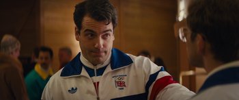 Movie still from “Eddie the Eagle” (2015), directed by Dexter Fletcher – A person wearing a jacket; Close Up shot, Over the shoulder angle