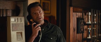Movie still from “Eddie the Eagle” (2015), directed by Dexter Fletcher – A person talking on a phone; Close Up shot, Over the shoulder angle