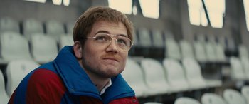 Movie still from “Eddie the Eagle” (2015), directed by Dexter Fletcher – A person wearing glasses; Close Up shot, Low angle