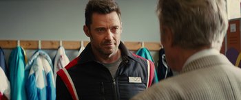 Movie still from “Eddie the Eagle” (2015), directed by Dexter Fletcher – A person wearing a jacket; Close Up shot, Over the shoulder angle