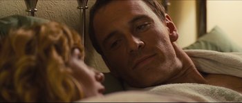 Movie still from “Eden Lake” (2008), directed by James Watkins – A person laying in a bed with a cat; Close Up shot, Over the shoulder angle