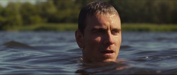 Movie still from “Eden Lake” (2008), directed by James Watkins – A person swimming in a body of water; Close Up shot, Over the shoulder angle