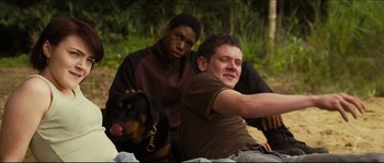 Movie still from “Eden Lake” (2008), directed by James Watkins – Two men and a dog sitting on the ground; Medium shot, Low angle