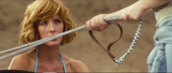 Movie still from “Eden Lake” (2008), directed by James Watkins – A woman is holding a rope in front of her face; Close Up shot, Over the shoulder angle