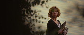 Movie still from “Eden Lake” (2008), directed by James Watkins – A woman standing in front of a body of water; Medium shot, Over the shoulder angle