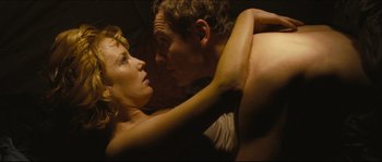 Movie still from “Eden Lake” (2008), directed by James Watkins – A man and a woman are laying on a bed together; Close Up shot, High angle