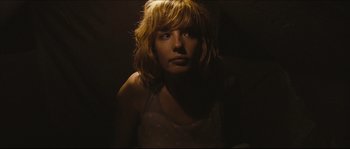 Movie still from “Eden Lake” (2008), directed by James Watkins – A woman with blonde hair is in the dark; Close Up shot, Low angle