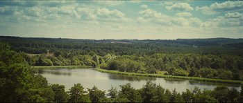 Movie still from “Eden Lake” (2008), directed by James Watkins – A view of a body of water surrounded by trees; Extreme Wide shot, High angle
