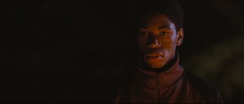 Movie still from “Eden Lake” (2008), directed by James Watkins – A man in a brown jacket is in the dark; Close Up shot, Low angle