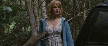 Movie still from “Eden Lake” (2008), directed by James Watkins – A woman standing in the woods near a tree; Medium shot, Low angle
