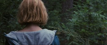 Movie still from “Eden Lake” (2008), directed by James Watkins – A woman standing next to a tree in the woods; Close Up shot, Over the shoulder angle
