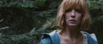 Movie still from “Eden Lake” (2008), directed by James Watkins – A person wearing a jacket near a forest; Close Up shot, Over the shoulder angle