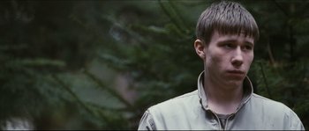 Movie still from “Eden Lake” (2008), directed by James Watkins – A man standing next to a tree in a forest; Close Up shot, Over the shoulder angle