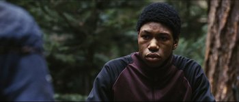 Movie still from “Eden Lake” (2008), directed by James Watkins – A young man in a black hat and a maroon jacket; Close Up shot, Low angle