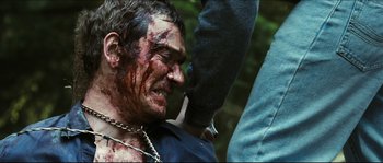 Movie still from “Eden Lake” (2008), directed by James Watkins – A man with blood all over his face and neck; Close Up shot, Over the shoulder angle