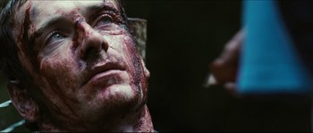 Movie still from “Eden Lake” (2008), directed by James Watkins – A man's face covered in blood; Close Up shot, Over the shoulder angle