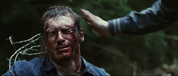 Movie still from “Eden Lake” (2008), directed by James Watkins – A man with blood all over his face and a hand touching his forehead; Close Up shot, Over the shoulder angle