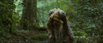 Movie still from “Eden Lake” (2008), directed by James Watkins – A woman in a dress in the woods with her hair blowing in the wind; Medium shot, Low angle