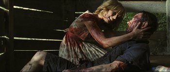 Movie still from “Eden Lake” (2008), directed by James Watkins – A woman in a red dress with blood on her face; Medium shot, Over the shoulder angle