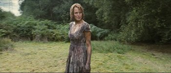 Movie still from “Eden Lake” (2008), directed by James Watkins – A woman in a dress standing in the grass; Medium shot, Low angle