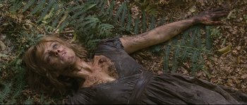 Movie still from “Eden Lake” (2008), directed by James Watkins – A woman laying on the ground covered in dirt; Medium shot, Overhead angle