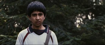 Movie still from “Eden Lake” (2008), directed by James Watkins – A young man with a bag standing in front of a tree; Close Up shot, Over the shoulder angle