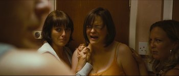 Movie still from “Eden Lake” (2008), directed by James Watkins – Two women standing next to each other holding hands; Medium shot, Over the shoulder angle