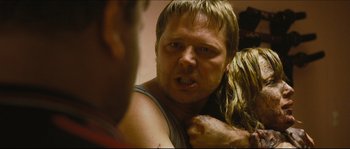 Movie still from “Eden Lake” (2008), directed by James Watkins – A person holding a person's face; Close Up shot, Over the shoulder angle