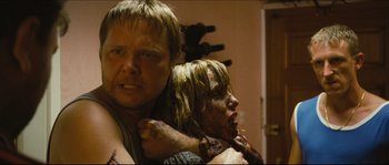 Movie still from “Eden Lake” (2008), directed by James Watkins – A man and a woman are holding each other in a room; Close Up shot, Over the shoulder angle