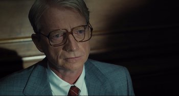Movie still from “The Post” (2017), directed by Steven Spielberg – An older man wearing a suit and tie; Close Up shot, Over the shoulder angle