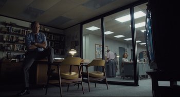 Movie still from “The Post” (2017), directed by Steven Spielberg – A man and a woman are sitting at a table in front of a window; Wide shot, Low angle