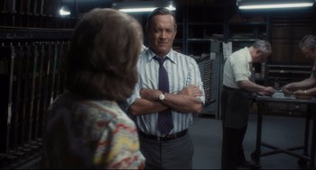 Movie still from “The Post” (2017), directed by Steven Spielberg – A man standing next to a woman with his arms crossed; Medium shot, Over the shoulder angle