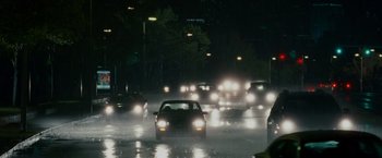 Movie still from “Edge of Darkness” (2010), directed by Martin Campbell – Cars driving down a wet street at night; Wide shot, High angle