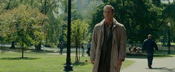 Movie still from “Edge of Darkness” (2010), directed by Martin Campbell – A man standing in the grass near a tree; Medium shot, Over the shoulder angle